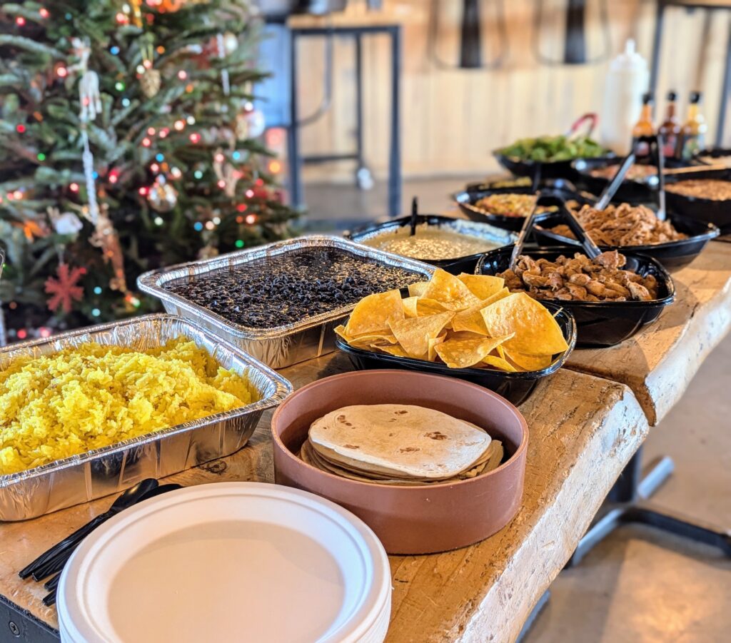 Catering trays of yellow rice, black beans, warm flour tortillas, tortilla chips and queso set up for a holiday event catered by Gordingo's in Brevard, NC