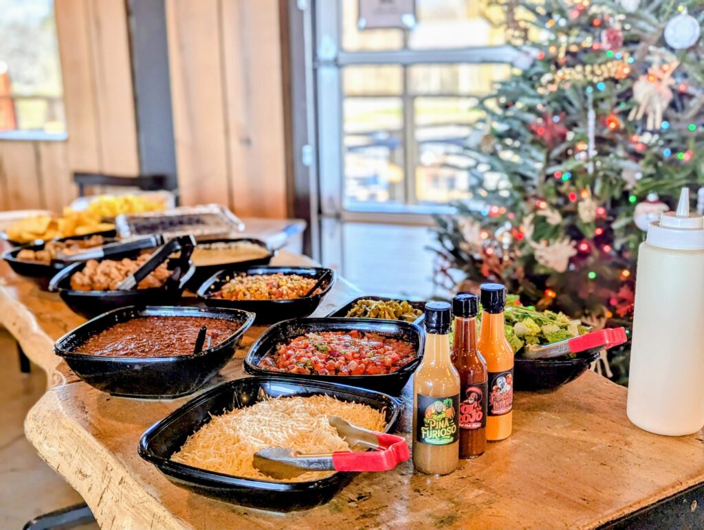 Gordingo's catering spread on a live-edge wood table inside the Brevard venue, with pico de gallo, beans, shredded cheese, salad and house hot sauces